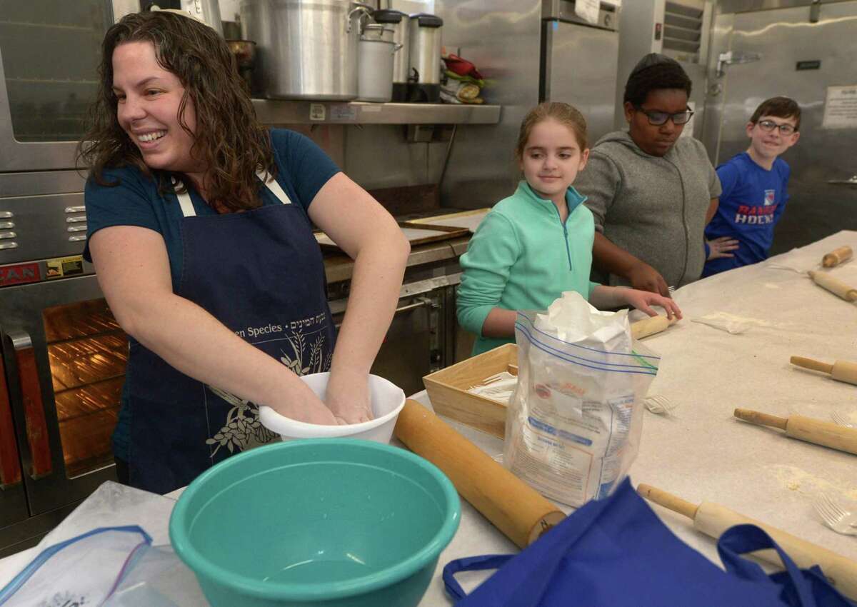 Congregation Beth El Rabbi Ita Paskind teaches students at their Hebrew school how to make matzo Tuesday at the synagogue in Norwalk. For the first time, Congregation Beth El-Norwalk has taken steps toward recognizing the increase in interfaith marriages, giving voting rights to family members who are not Jewish. In addition, it changed language regarding officers to be gender neutral.