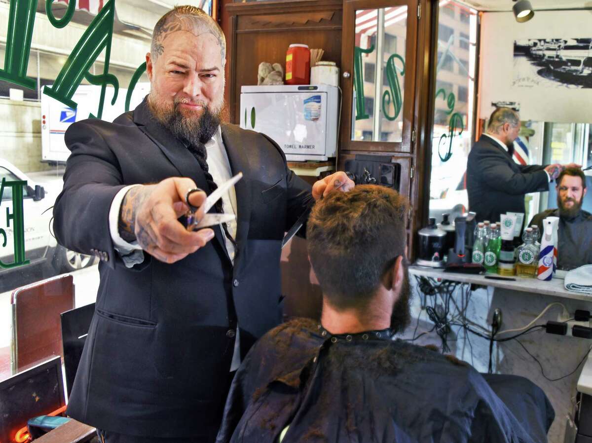 William Yager, center, owner of Patsy's Barber Shop, with customer Dan Atkins of Albany, at his shop Tuesday March 6, 2018 in Albany, NY. (John Carl D'Annibale/Times Union)