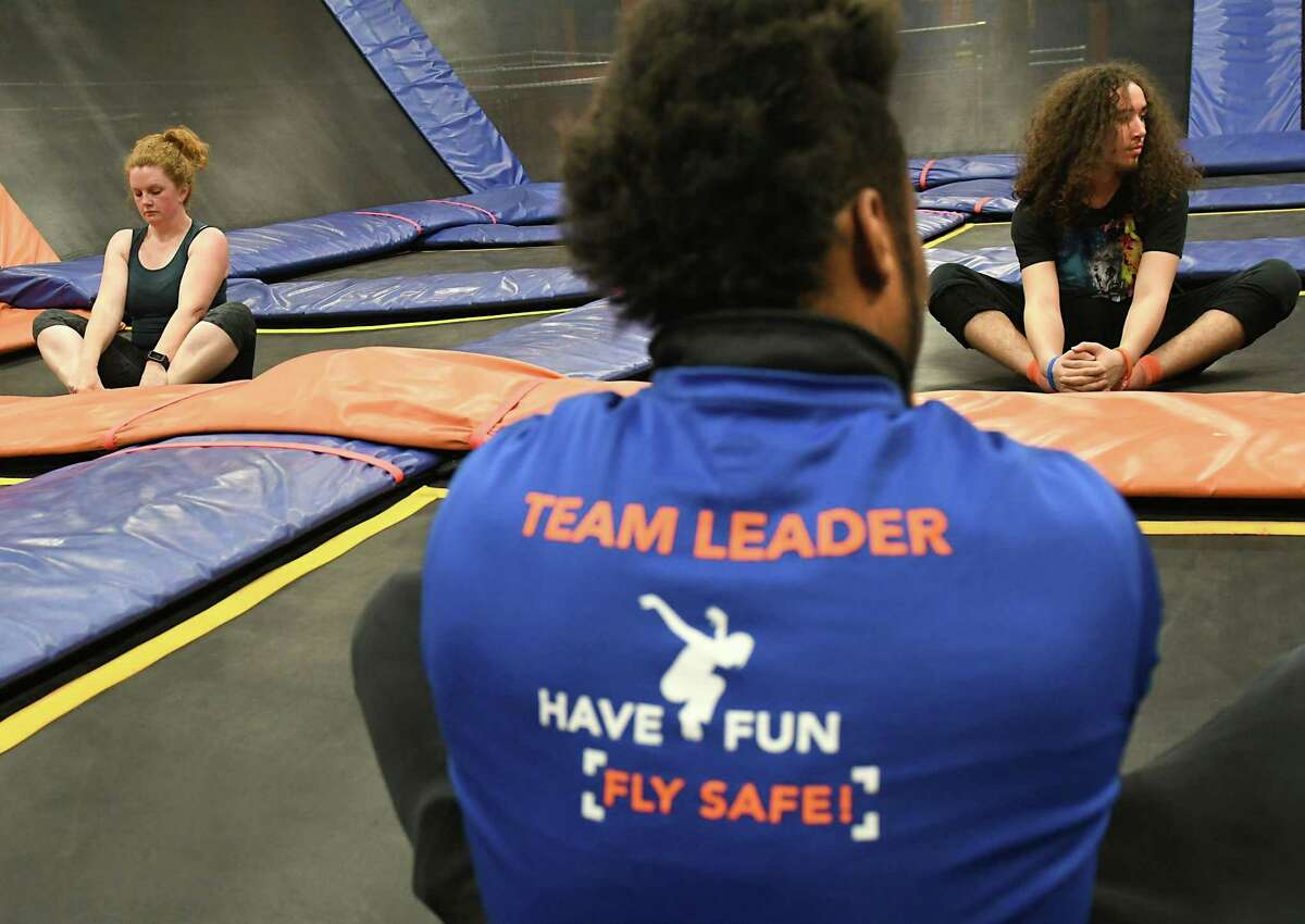 Instructor A. J. Burnett, center, has his students Times Union reporter Leigh Hornbeck, left, and Edwin Maldonado of Troy stretch at the end of a a SkyFit class at Sky Zone Trampoline Park on Wednesday, March 14, 2018 in Albany, N.Y. (Lori Van Buren/Times Union)