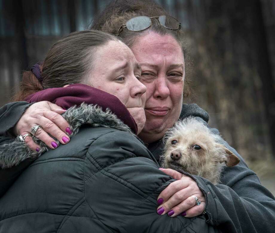 Residents of the fire building give one of the surviving pets a hug at the scene of a two-alarm fire at 158 6th Avenue Thursday March 29, 2018 in Troy, N.Y. A number of house pets were saved and a few were lost in the smokey blaze. (Skip Dickstein/Times Union) Photo: SKIP DICKSTEIN, Albany Times Union