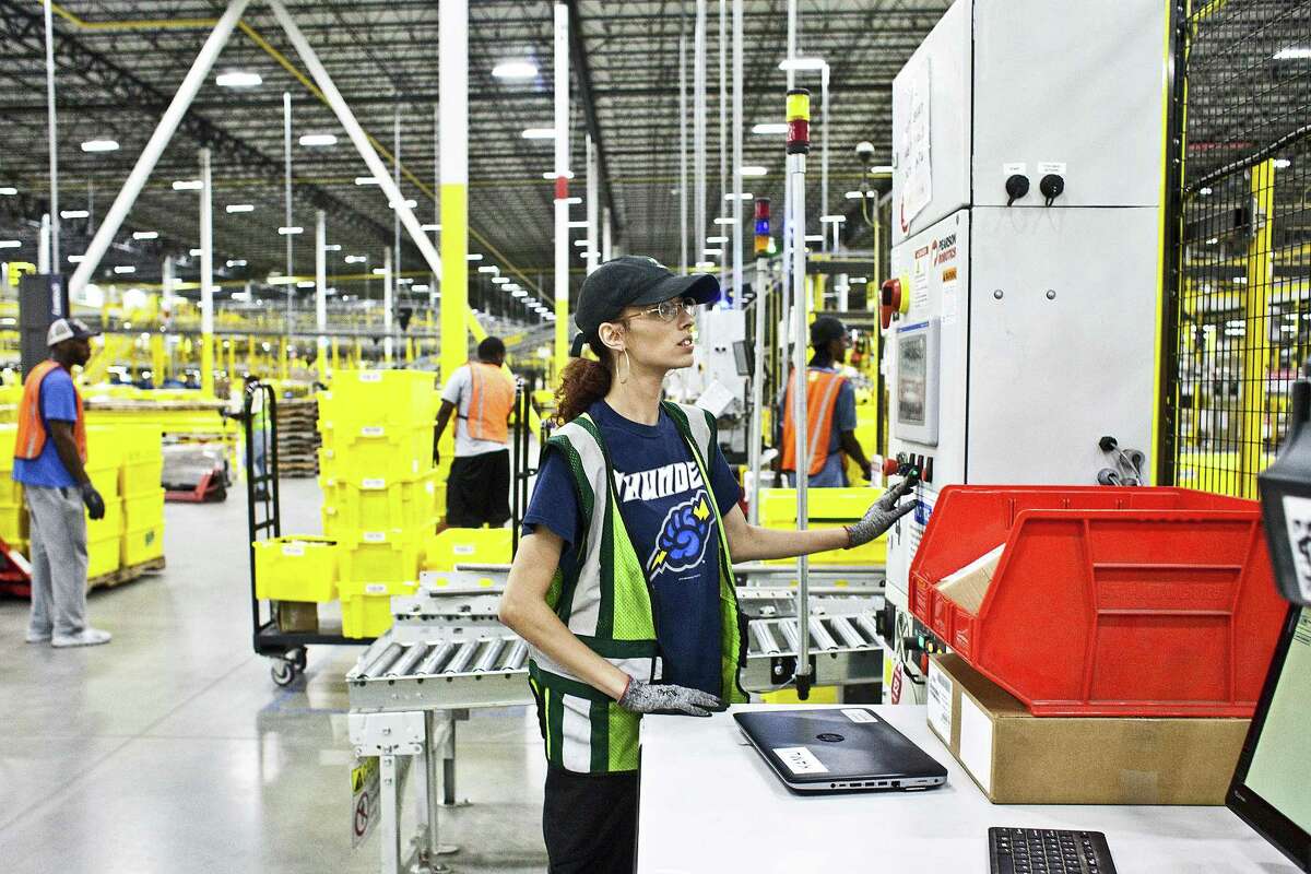 Nissa Scott monitors a console that controls robots in an Amazon warehouse in Florence, N.J.