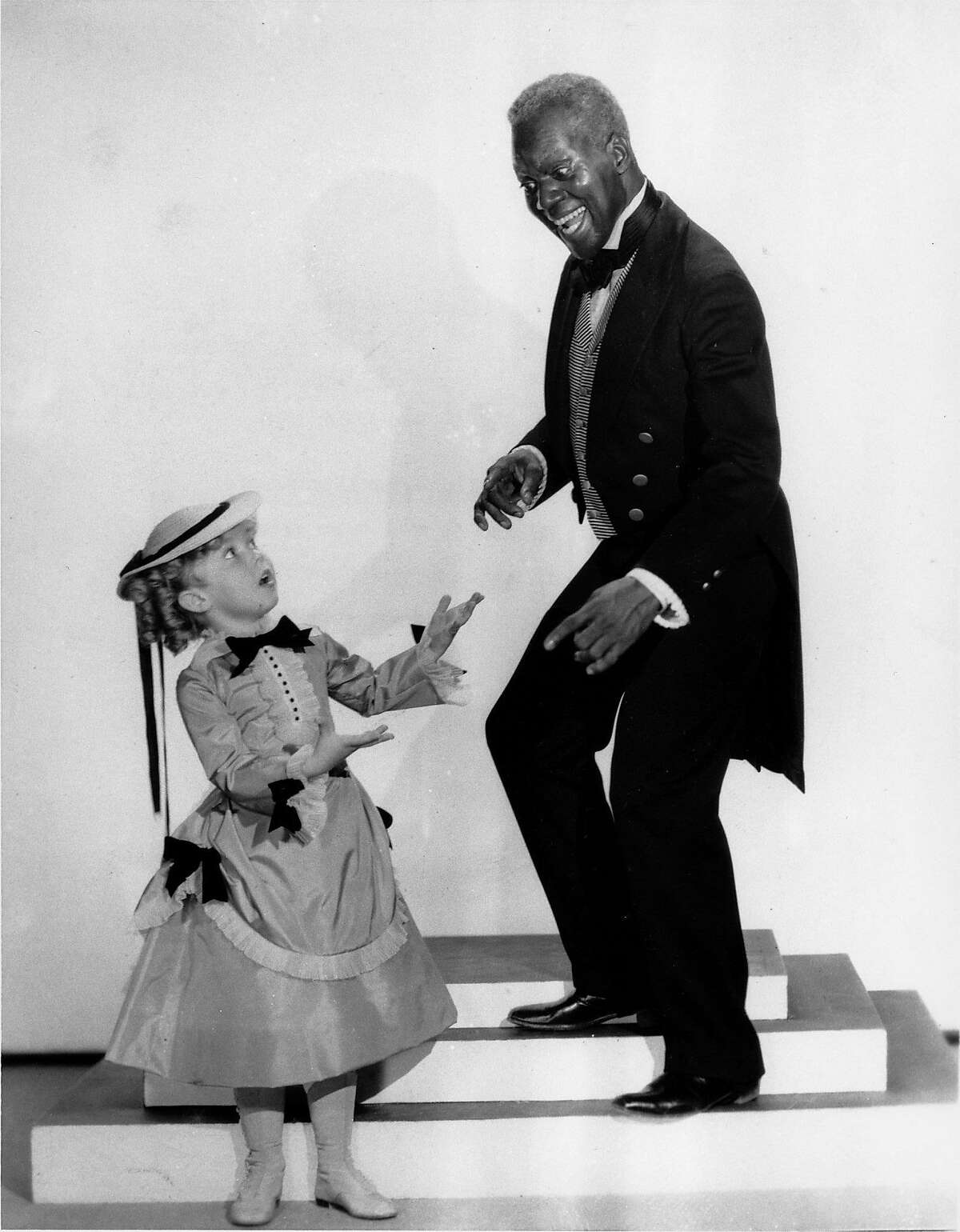 Shirley Temple and tap dancer Bill "Bojangles" Robinson are shown in a scene from the 1935 motion picture "The Little Colonel," one of four movies they appeared in together. (AP Photo)
