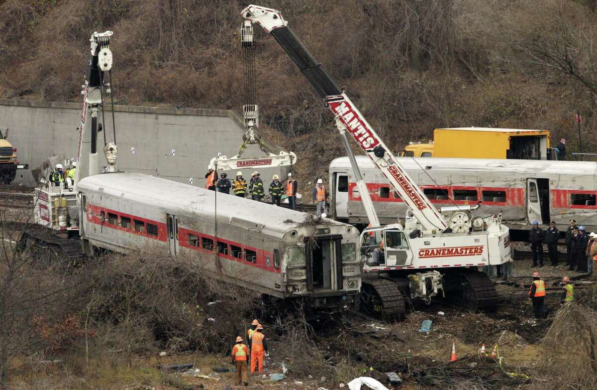 Cranes salvage the last car from from a train derailment in the Bronx section of New York, Monday, Dec. 2, 2013. Federal authorities started an exhaustive investigation into what caused a Metro-North commuter train rounding a riverside curve to derail, killing four people and injuring more than 60 others.