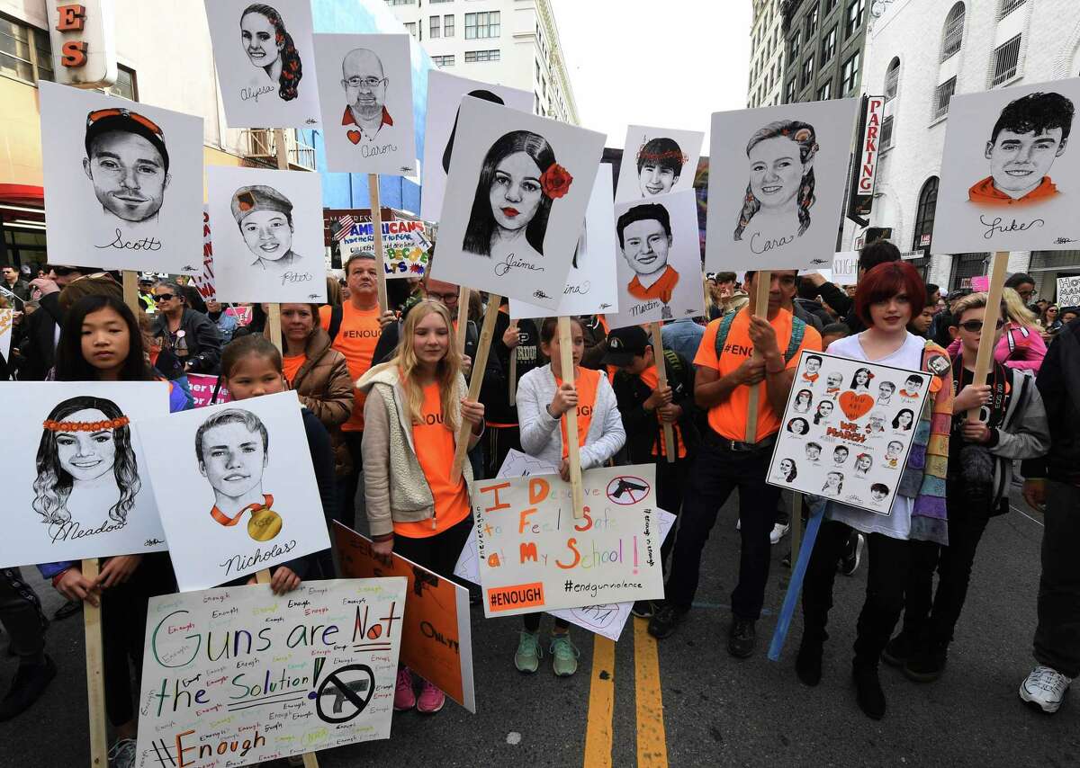 Students hold portraits of victims of Florida’s Marjory Stoneman Douglas High School shootings as people protest for tighter gun laws during the student organized ‘March For Our Lives’ rally in Los Angeles on March 24. Critics say the marchers cast spurious charges against those legitimately supporting gun rights.
