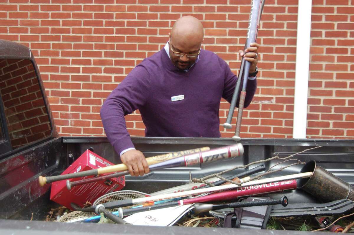Boys and Girls Club of Greenwich CEO Bobby Walker Jr. removes some baseball bats from the truck of State Rep. Fred Camillo. Camillo led a drive for new and used sports equipment in town for the third year, donating the equipment to the club for use by its members