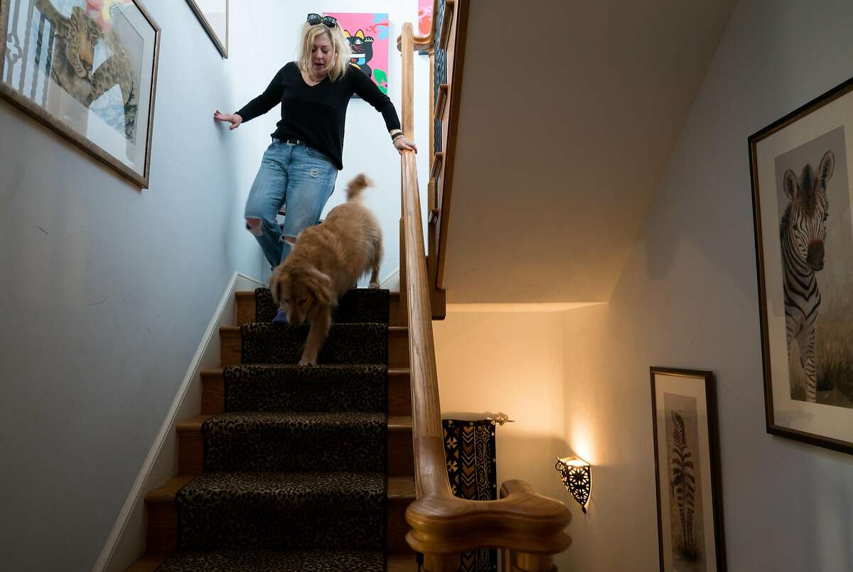Leigh Anne Varney walks down the stairs with her dog, Callie, inside of her Outer Richmond home in San Francisco, Calif. on Friday, March 30, 2018.