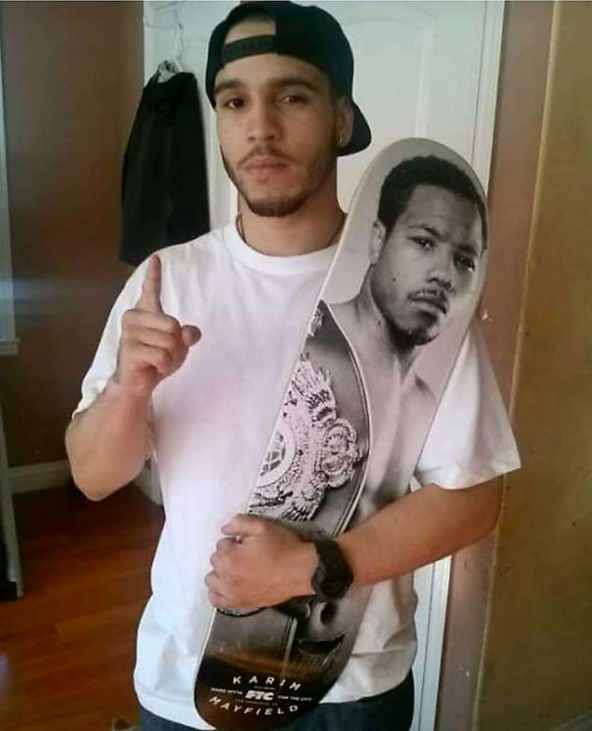 Sahleem Tindle, brother of boxer Karim Mayfield, holds a skateboard with his brother's likeness. Sahleem Tindle was shot and killed by a BART police officer in Oakland back on Jan. 3, 2018. Courtesy Karim Mayfield