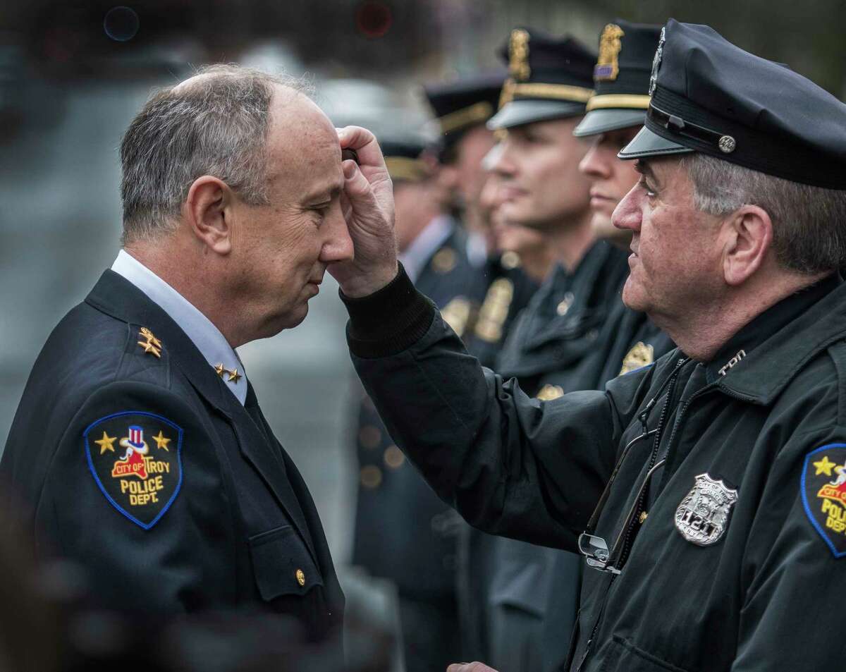 Assistant Chief of Department George VanBramer, left, receives a blessing from police chaplin officer Paul Carney at his retirement ceremony Friday March 30, 2018 outside of police headquarters in Troy, N.Y. (Skip Dickstein/Times Union)