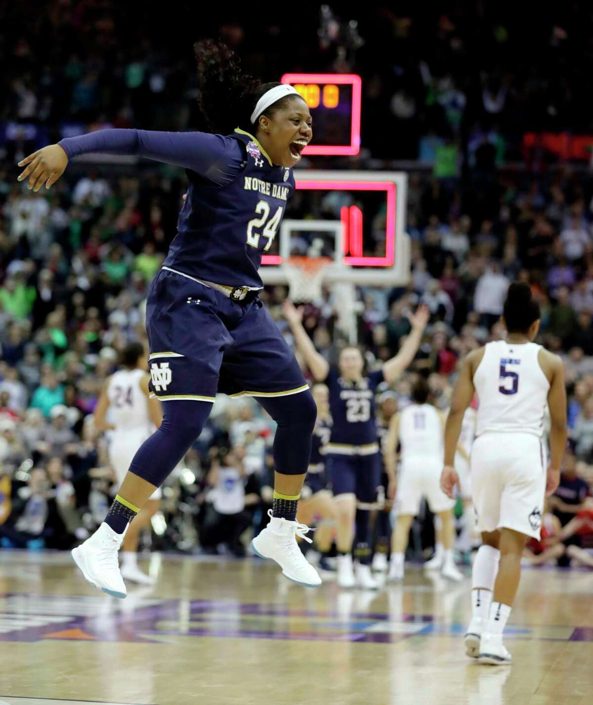 Notre Dame's Arike Ogunbowale (24) celebrates as Connecticut's Crystal Dangerfield (5) walks away as time expires in overtime in the semifinals of the women's NCAA Final Four college basketball tournament, Friday, March 30, 2018, in Columbus, Ohio. Notre Dame won 91-89. (AP Photo/Tony Dejak)
