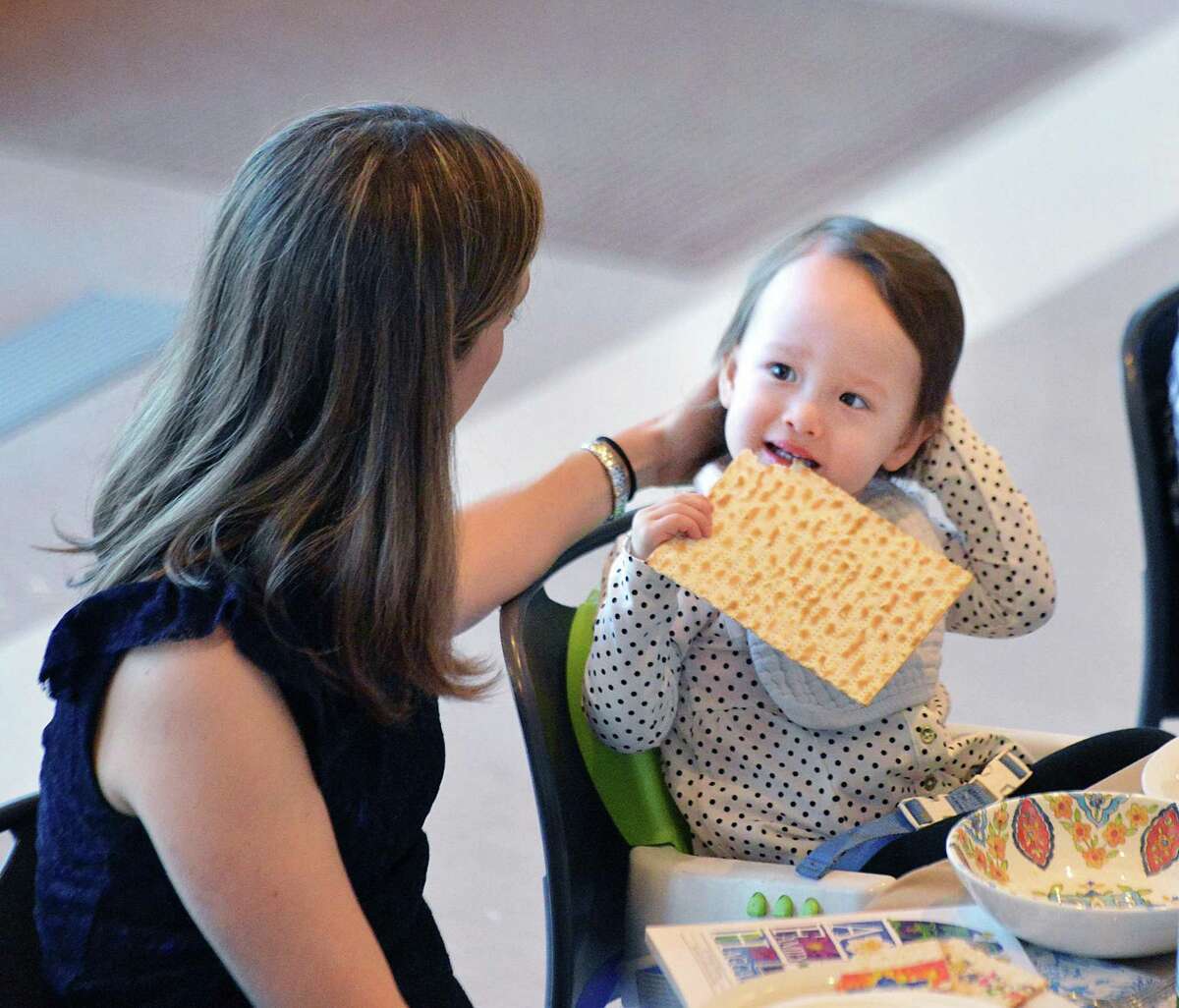 Norah Lee, 2, of Greenwich, enjoyed matzah during the community seder for Passover at the Greenwich Reform Synagogue in the Cos Cob section of Greenwich, Conn., Saturday night, March 31, 2018.