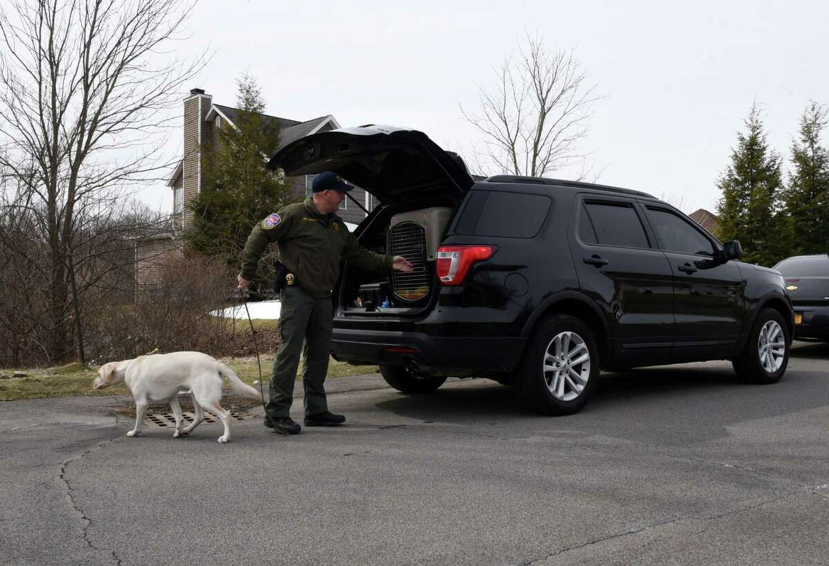 An FBI sniffer dog is brought to the home of NXIVM co-founder Nancy Salzman which was raided by federal agents on Tuesday, March 27, 2018, in Halfmoon, N.Y. Keith Raniere, the co-founder of the NXIVM corporation has been arrested by the FBI based on a federal criminal complaint filed in the Eastern District of New York. (Will Waldron/Times Union)