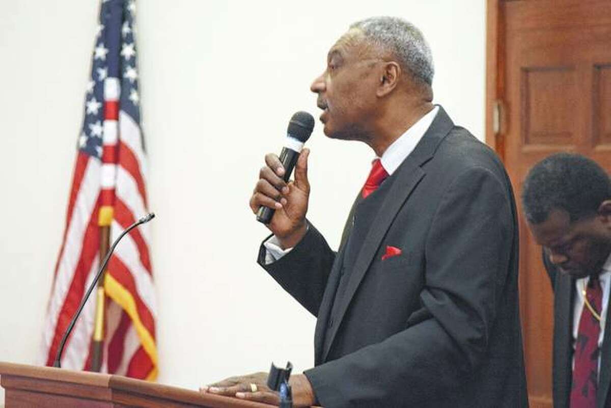 Pastor Samuel Holmes Sr. of Community Temple Church of God in Christ opens the service Saturday at his church.