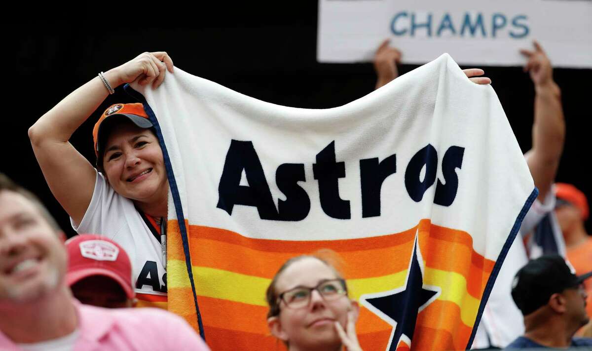 Houston Astros fans hold up a signs in the third inning of an MLB baseball game at Globe Life Park, Sunday, April 1, 2018, in Arlington.