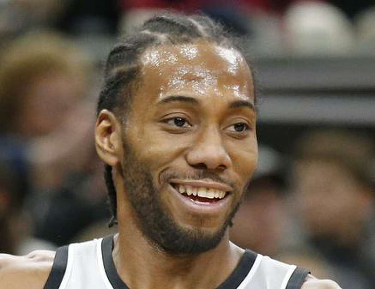 San Antonio Spurs' Kawhi Leonard jokes with head coach Gregg Popovich on the bench during first half action against the Denver Nuggets Saturday Jan. 13, 2018 at the AT&T Center.