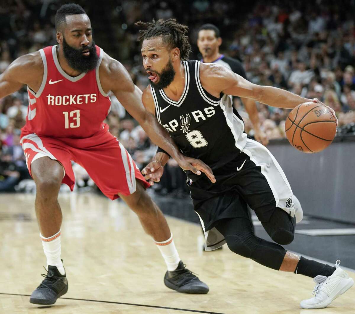 San Antonio Spurs' Patty Mills (8) drives against Houston Rockets' James Harden during the second half of an NBA basketball game Sunday, April 1, 2018, in San Antonio. San Antonio won 100-83. (AP Photo/Darren Abate)