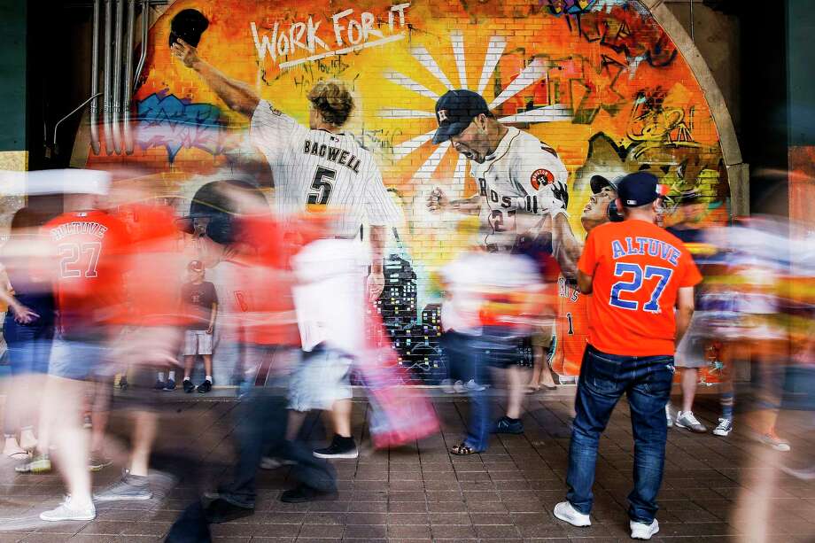 Fans walk past the Astros Street Art display in Home Run Alley as they head to their seats before the game. The graffiti artwork was painted by local artist Franky Cardona. Photo: Michael Ciaglo / Michael Ciaglo