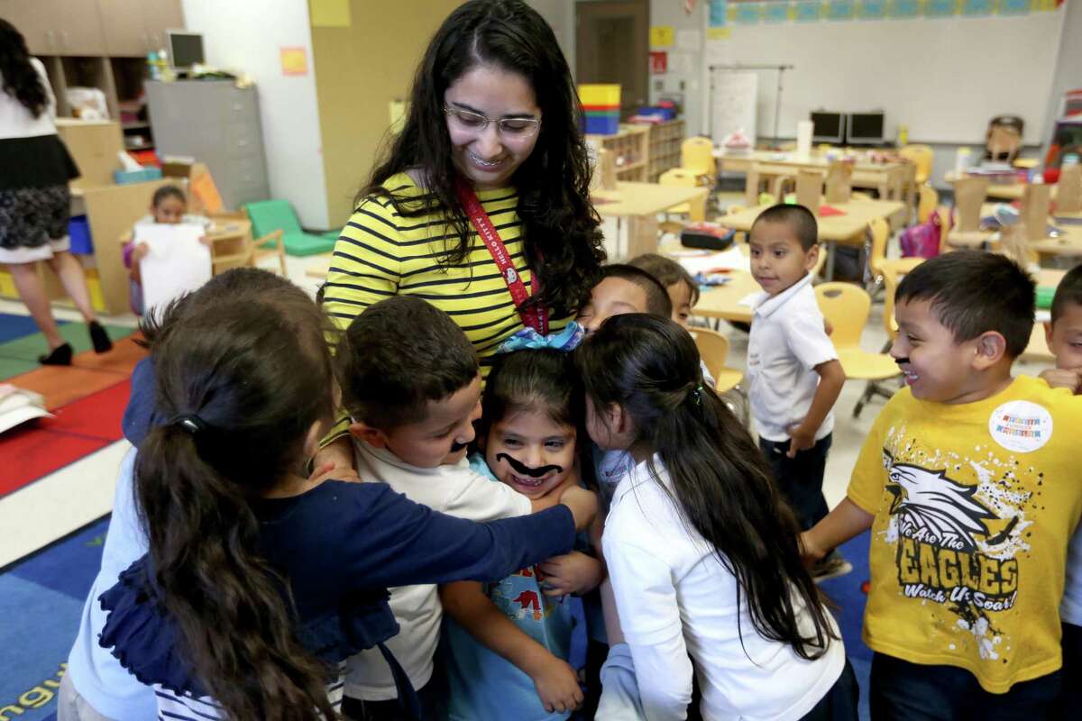 Pre-K teacher, receives a group hug from her students on the last day of school at John F. Kennedy Elementary School Wednesday, May 25, 2016, in Houston, Texas.
