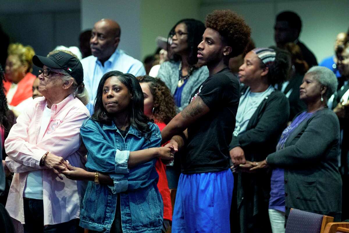 Those gathered to honor the life and service of The Rev. Dr. Martin Luther King, Jr., hold hands to sing "We Shall Overcome" at Wheeler Avenue Baptist Church on Wednesday, April 4, 2018, in Houston.