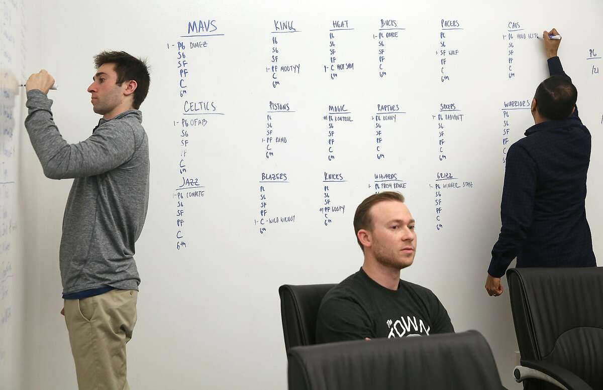 General manager for Santa Cruz Warriors Kent Lacob (left), VP of GSW sports ventures Kirk Lacob (middle) and director of basketball analytics Pabail Sidhu (right) from the Warriors' Gaming Squad gather at the Warriors offices in downtown Oakland to watch the proceedings on a screen and make decisions on top prospects on Wednesday, April 4, 2018, in Oakland, Calif.