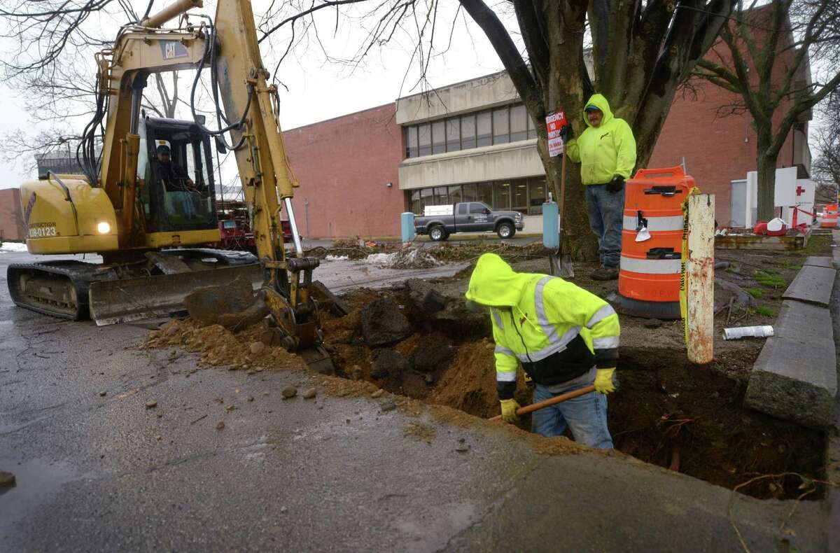 Workers with Grasso Construction dig an electrical trench for a mechanized gate and additional lighting Tuesday, April 3, 2018, in the parking lots adjacent to the Norwalk Library Main Branch on Mott Avenue as part of merging the library?’s small lot with the newly acquired private lot immediately to the west in Norwalk, Conn. The reconfiguration will create a single lot available to library patrons with validation.