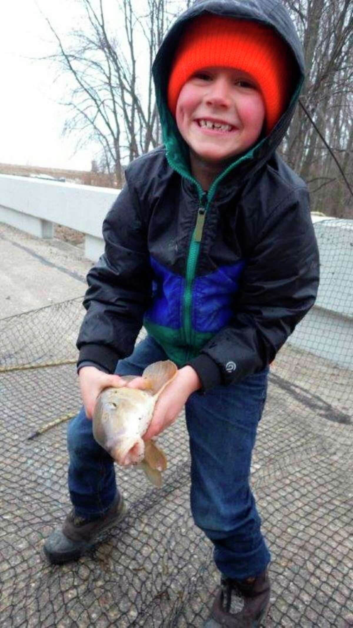 Raiden Peacock of Midland, 6, was excited to lift a large sucker out of the net last Saturday during the Talaski clan's annual spring fishing get-together in the Thumb. (Tom Lounsbury/Hearst Michigan)