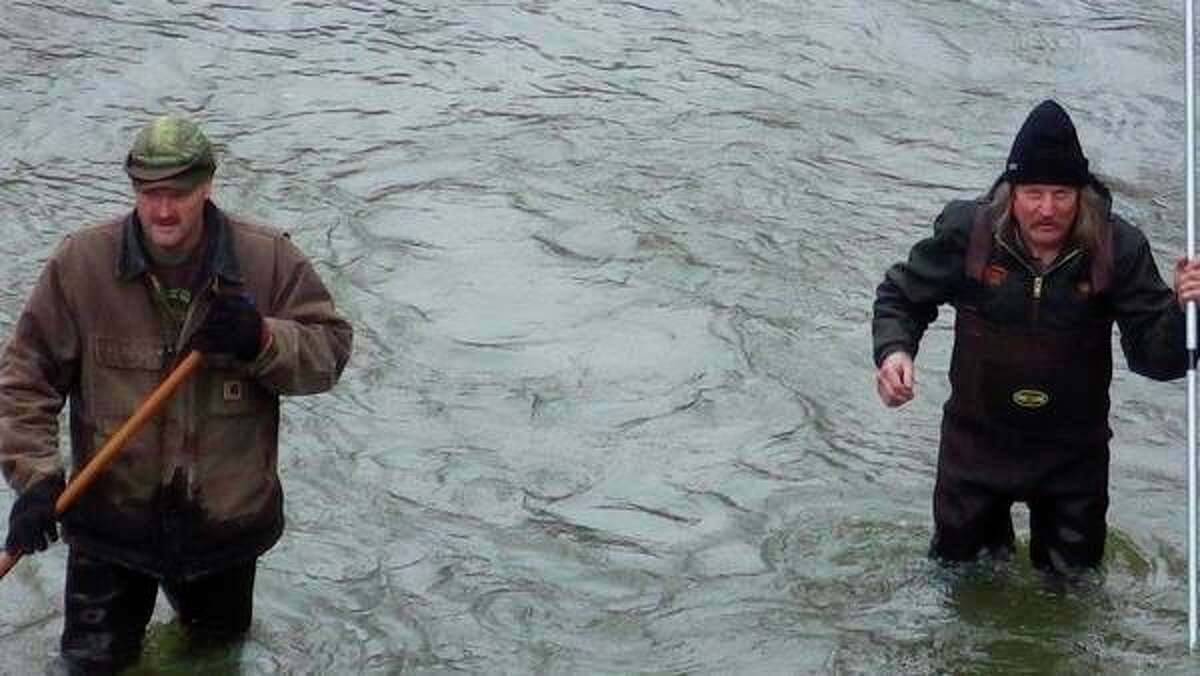 Above, Bob Papke, left, of Bad Axe, and Tim Talaski, of Three Rivers, use fish spears while herding suckers toward waiting dip-nets. Talaski can testify that a fish spear also makes a great wading staff for negotiating in a fast current. Right, Raiden Peacock of Midland, 6, was excited to lift a large sucker out of the net last Saturday during the Talaski clan's annual spring fishing get-together in the Thumb. (Tom Lounsbury/Hearst Michigan)