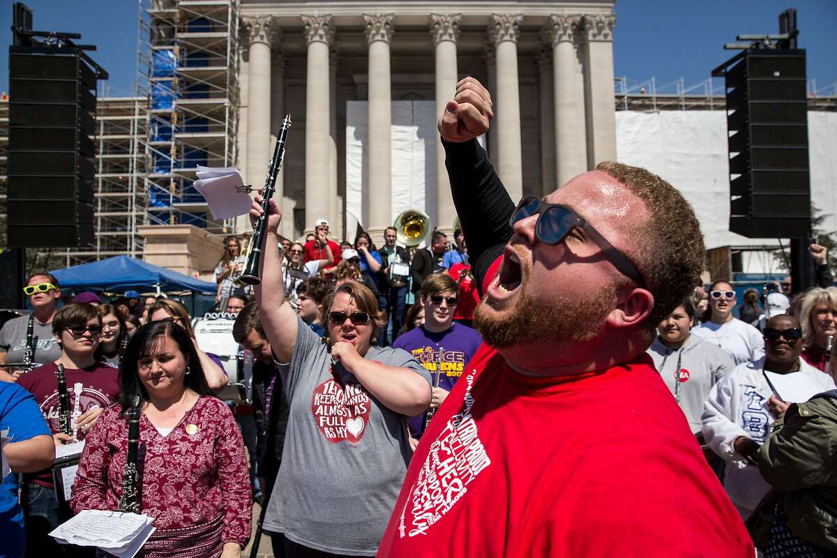 OKLAHOMA CITY, OK - APRIL 04: Putnam City West band director Edward Hudson leads the The Oklahoma Teacher Walkout Band, an improvised group of music teachers from across the state, in a pep rally on the steps of the state Capitol on April 4, 2018 in Oklahoma City, Oklahoma. Teachers and their supporters are demanding increased school funding and pay raises for school workers. (Photo by Scott Heins/Getty Images)