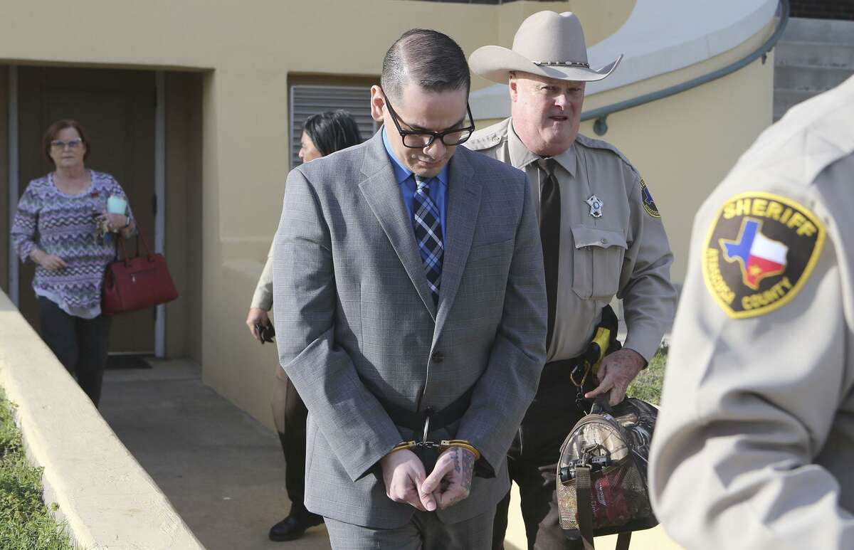 Murder defeandant Shaun Puente (center, cuffed) leaves court in Jourdanton, Texas Thursday March 8, 2018. Shaun Puente is accused in the 2013 murder of San Antonio police officer Robert Deckard. Puente is accused of shooting Deckard,31, in the forehead as he led a chase from San Antonio into Atascosa County.