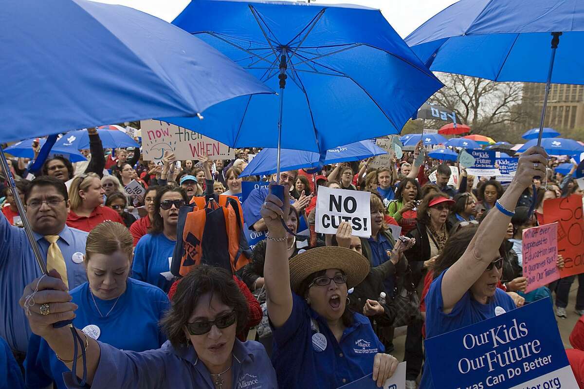 Texas’ rainy day fund faces many demands — here, teachers in 2011 hold umbrellas to make the point that, for public schools, it’s raining. A Legacy Fund would allow the state to address long-term obligations free from the endless cycle of two-year budgets.