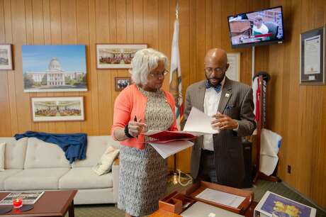 Assemblymember Mike Gipson, D-Carson, works in his office with scheduler Elaine E. Douglas at the state Capitol in Sacramento, Calif. on Wednesday, April 4, 2018. Gipson introduced a law that would enact a moratorium on arrests for minor offenses in foster-care facilities. He plans to introduce a $7.5 million budget proposal to better train facility staff and police, and fund diversion programs to keep foster youth out of the criminal justice system.