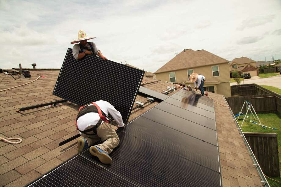 Workers from Alba Solar install solar panels on a home on Upland Sprint Terrace, Katy Texas, June 21, 2017. ( David A. Funchess / Houston Chronicle ) Photo: David A. Funchess, HC Staff Intern / David A. Funchess / Houston Chronicle