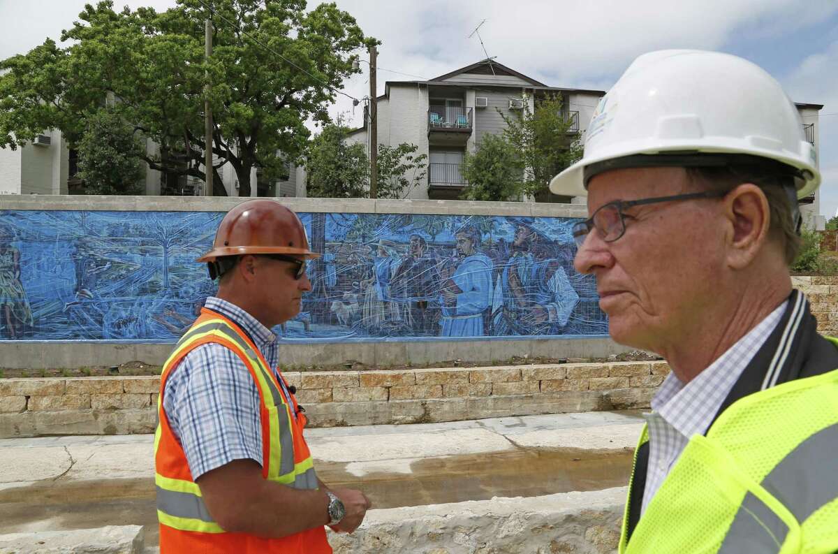 Kerry Averyt, a senior engineer with the San Antonio River Authority, and Bexar County Judge Nelson Wolff (right) toured the first phase of the San Pedro Creek Culture Park about a month before it opened. Averyt is project manager of the San Pedro Creek renovations. The Soap Factory Apartments are shown in the background.