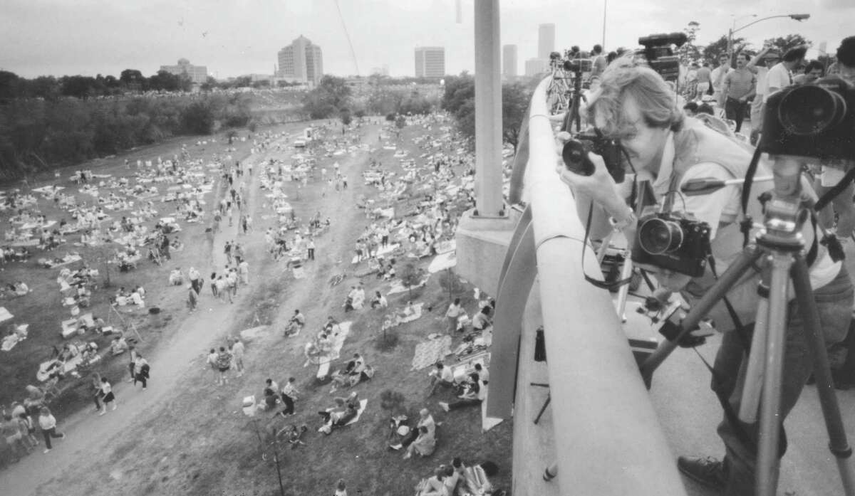 Photographer Antony Hayward leans over the Taylor Street bridge to get a good angle of the skyline and the crowd below, waiting for Jean-Michel Jarre’s “Rendezvous Houston: A City In Concert” light show to begin, April 5, 1986. The show is part of 1986 Houston Festival and celebrates the 150th birthdays of Texas and Houston and the 25th birthday of the National Aeronautics and Space Administration.