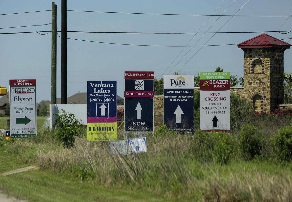 Builder signs for neighborhoods, including Elyson, in northwest Harris County, photographed on Wednesday, April 4, 2018, in Katy. The developer avoided flood plain regulations by using dirt (fill) to raise the home sites above the level of the flood plain.( Elizabeth Conley / Houston Chronicle )