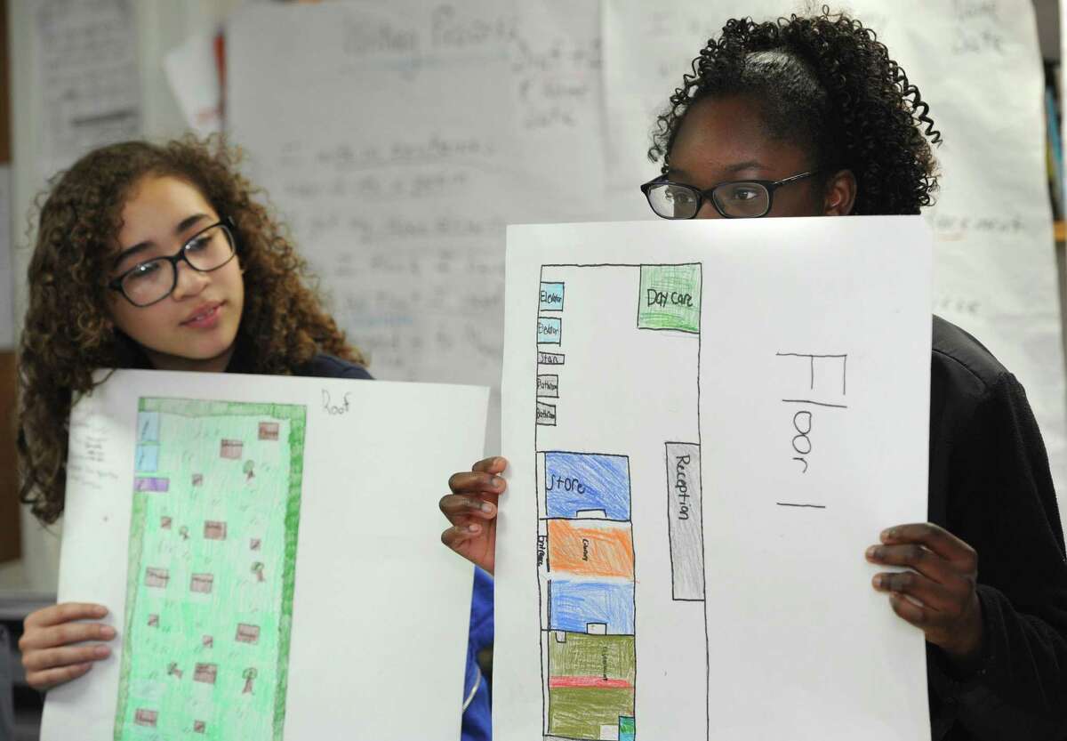 Seventh grade students at Side by Side School including Onjolie Bedoja and Leah Pettway work with artist-in-residence, Jean-Marc Superville Sovak, as they present their design projects Friday, April 6, 2018, as part of the Common Ground program which is in it's 4th year at the school in Norwalk, Conn. The Common Ground program is a collaboration between Side by Side School and The Aldrich Contemporary Art Museum in Ridgefield and brings the artist-in-residence to the school to work with students on socially conscious projects.
