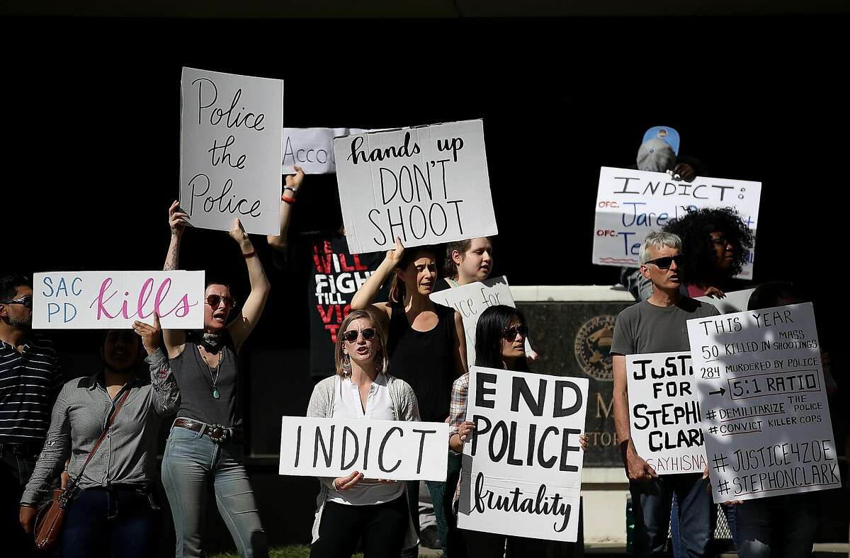 Black Lives Matter protesters hold signs as they stage a demonstration outside of office of Sacramento district attorney Anne Schubert on March 29, 2018 in Sacramento, California. Hours after the funeral for Stephon Clark, doze