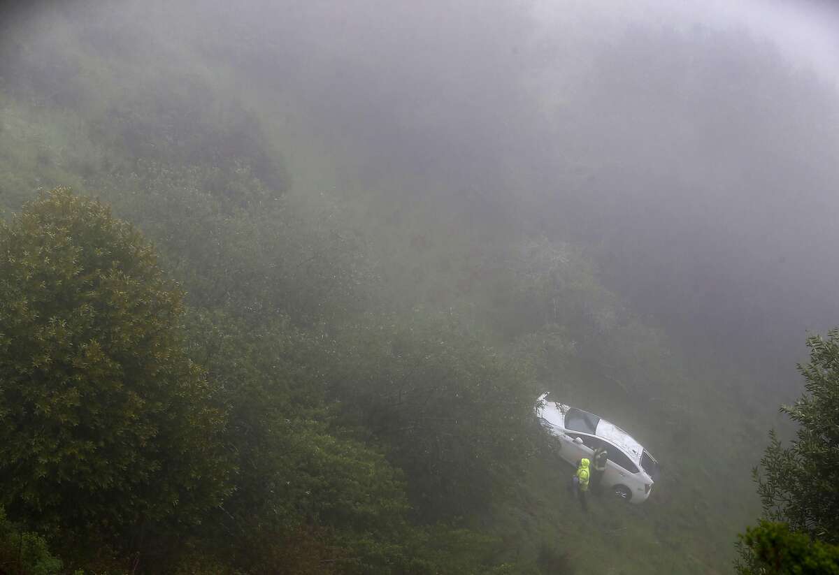 Tow truck personnel retrieve a white Prius from a steep ravine off Grizzly Peak Boulevard in Oakland, Calif. on Friday, April 6, 2018 which was discovered about 400 feet down the hill and reportedly belongs to a woman reported missing earlier this week.