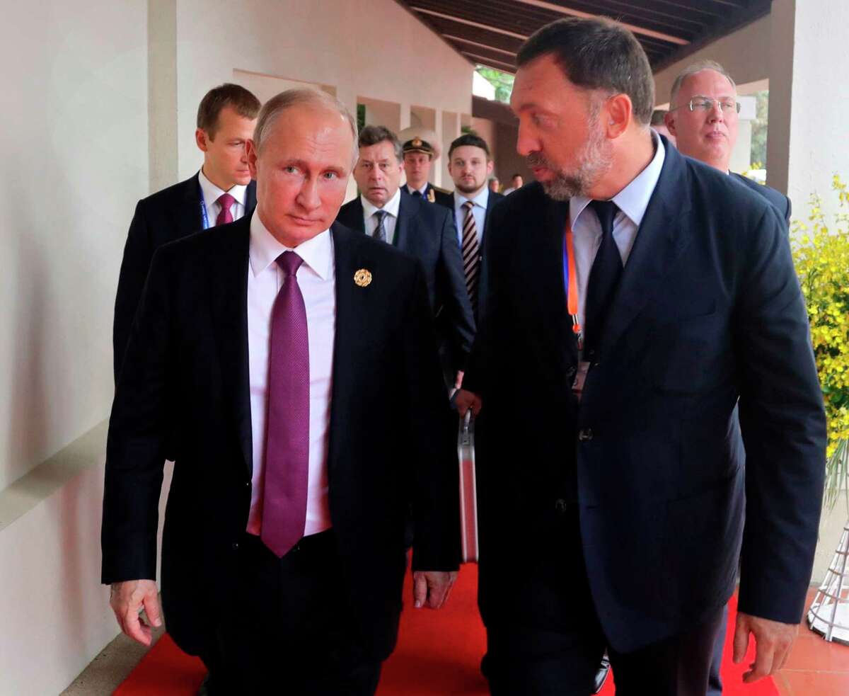 File-This Nov. 10, 2017, file photo shows Russia's President Vladimir Putin, left, and Russian metals magnate Oleg Deripaska, right, walking to attend the APEC Business Advisory Council dialogue in Danang, Vietnam. The United States punished dozens of Russian oligarchs and government officials on Friday, April 6, 2018, with sanctions that took direct aim at President Putin's inner circle, as President Donald Trump's administration tried to show he's not afraid to take tough action against Moscow. Seven Russian tycoons, including aluminum magnate Deripaska, were targeted, along with 17 officials and a dozen Russian companies, the Treasury Department said. (Mikhail Klimentyev, Sputnik, Kremlin Pool Photo via AP, File)