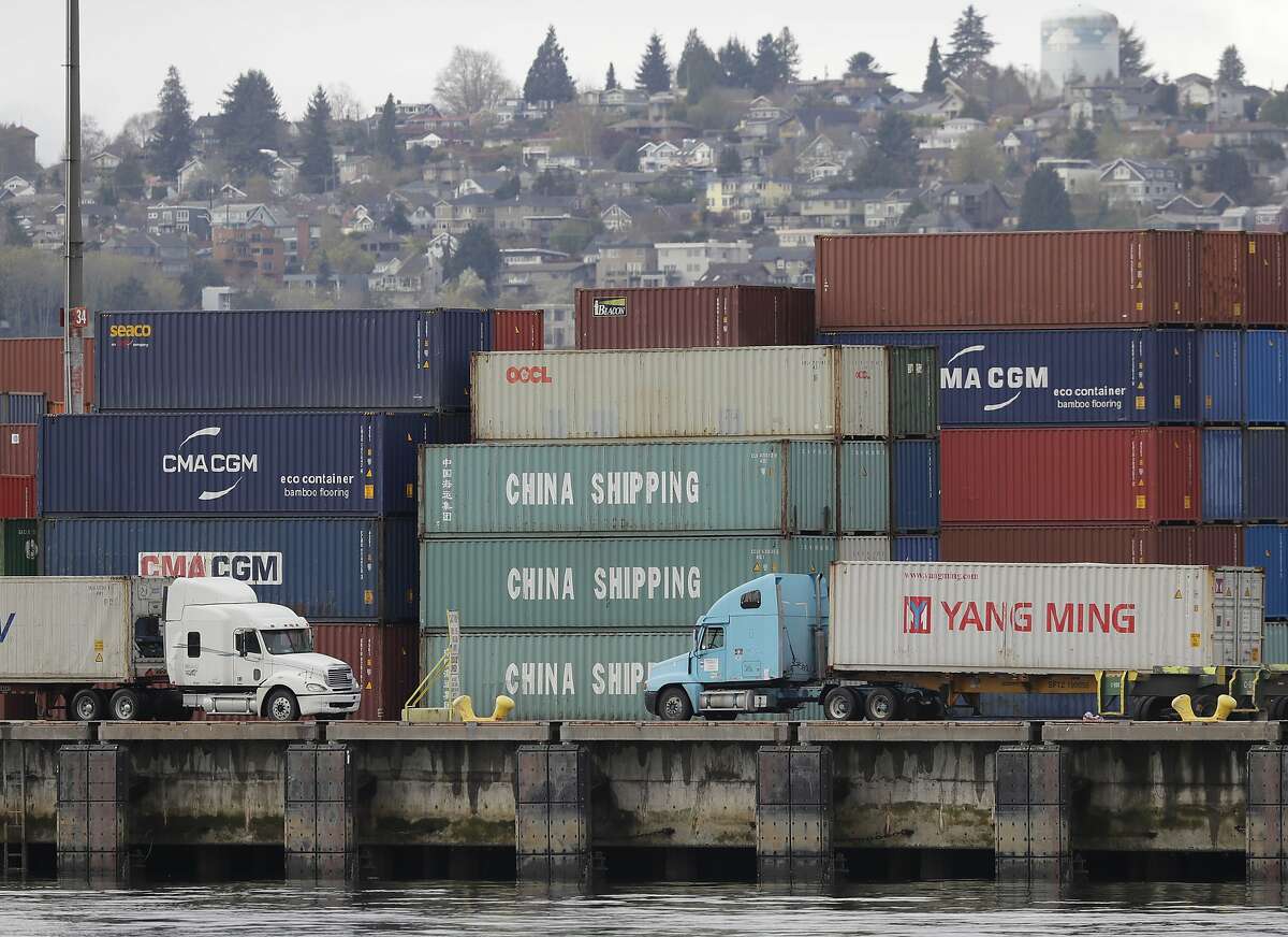 Trucks pass by cargo containers labeled "China Shipping," Friday, April 6, 2018, at the Port of Seattle. On Thursday, President Donald Trump ordered the government to consider a bigger set of tariffs on goods imported from China. (AP Photo/Ted S. Warren)