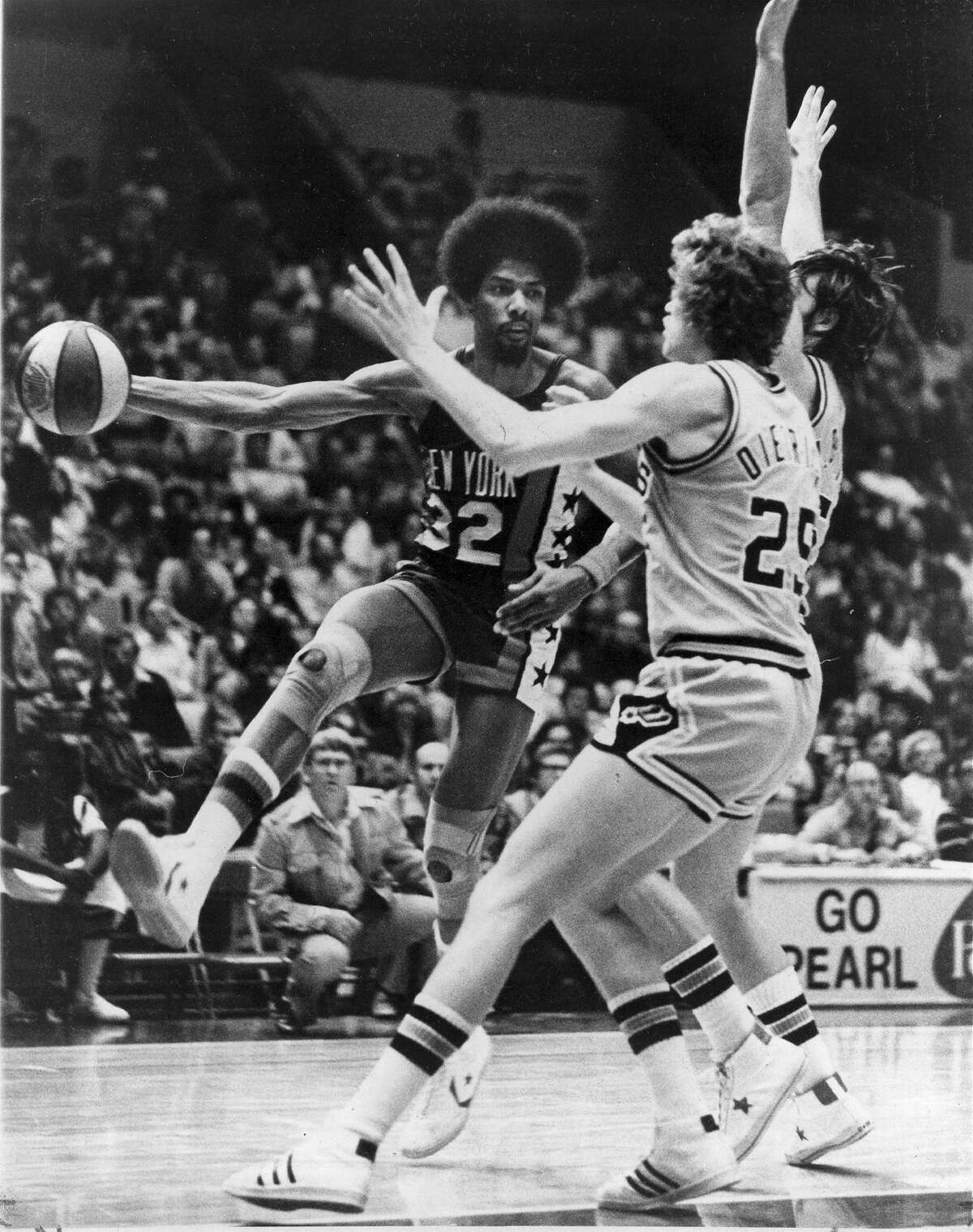The New York Nets' Julius Erving drives around the Spurs' Coby Dietrick (25) and Mark Olberding during a regular-season ABA game at HemisFair Arena on Jan. 6, 1976.