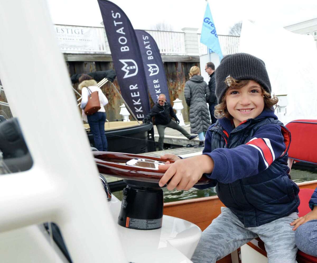 Mason Holl, 7, of Westport, smiled as he took the wheel of a motorboat during the 10th annual Greenwich Boat Show at the Greenwich Water Club in the Cos Cob section of Greenwich, Conn., Saturday, April 7, 2018.