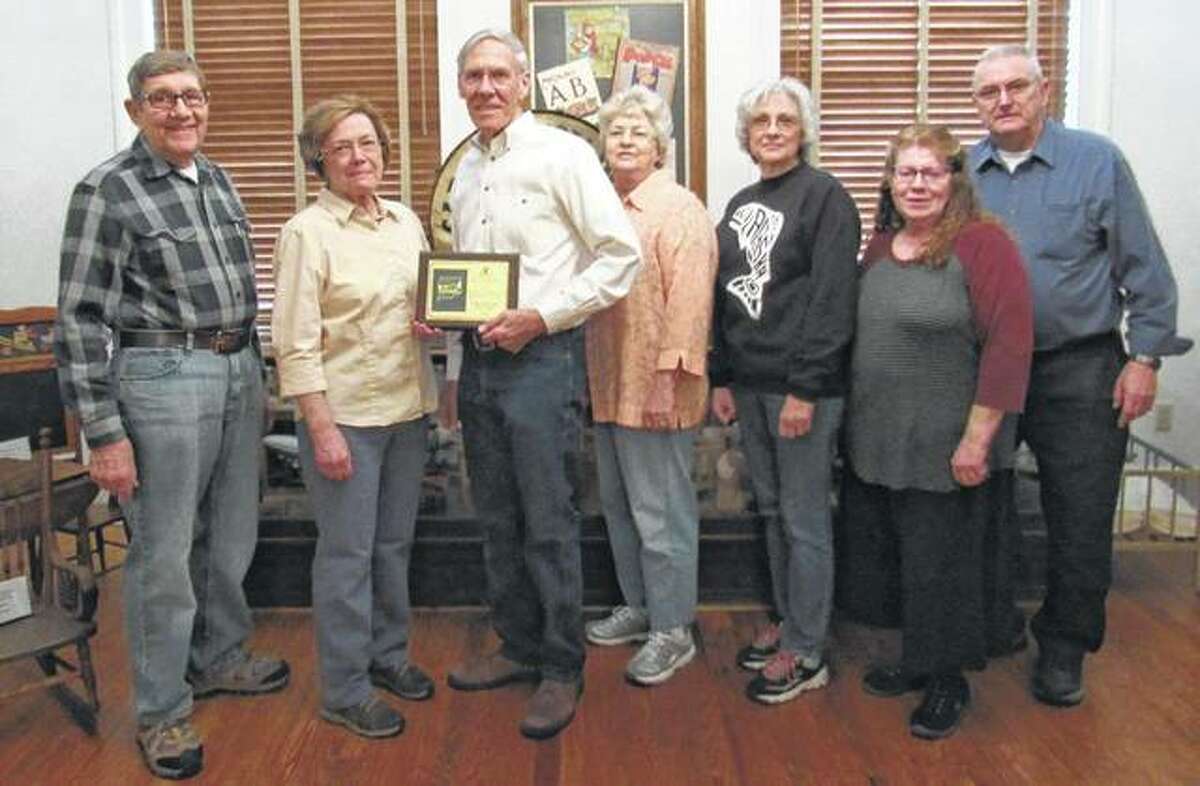 Greene County Historical and Genealogical Society recently received the 2016 Excellence Award from Acclaim Press for its “Greene County, Illinois, History and Families” book that was published in September 2016. Criteria for the award, presented by Douglas Sikes of Acclaim Press, included aesthetic appeal, literary content and commercial success. Historical society members on hand to accept the award included Larry Gillingham (from left), Terry Kruckeberg, President Steve Black, Margaret Camerer, Mary Varble, Jean Coates and Gary Coates. Black noted that more than 500 families helped to make the book by submitting stories and histories relating to their ancestors. Copies of the book are available for $65 at the GCHGS office in Carrollton.