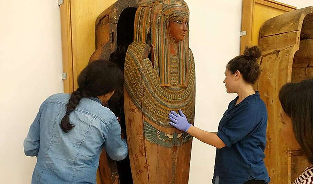 Students in San Francisco State University's Museum Studies program install the lip of a rare triple-nesting Egyptian sarcophagus in the new Global Museum on campus, which��April 26.