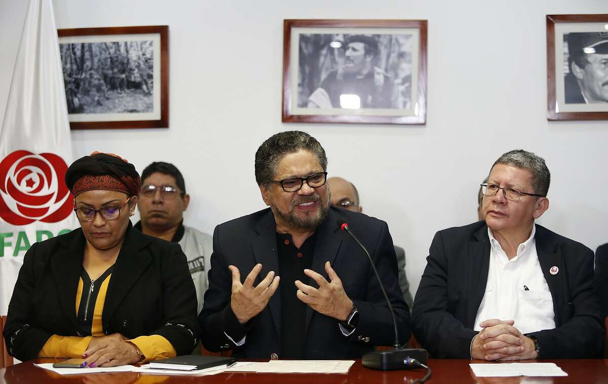 Ivan Marquez, a former leader of the Revolutionary Armed Forces of Colombia, FARC, center, gestures as he speaks to the media as Victoria Sandino, left, and Pablo Catatumbo, right, listen during a press conference in Bogota, Colombia, Tuesday, April 10, 2018. Seuxis Hernandez, a blind rebel ideologue best known by his alias Jesus Santrich, was picked up Monday at his residence in Bogota on charges that he conspired with three others to smuggle several tons of cocaine into the U.S. with a wholesale value of $15 million. (AP Photo/Fernando Vergara)