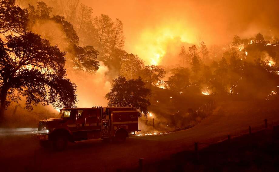 A Cal Fire truck is driven away from flames as the Rocky fire burns near Clear Lake, California on August 2, 2015. The fire has charred more than 27,000 acres, and is currently only 5% contained. Photo: Josh Edelson / Getty Images