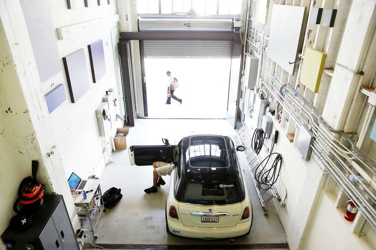 Patrick Handy installs the electronics needed to add the privately owned vehicle to the Getaround car sharing system at the company's headquarters on Tuesday, April 8, 2014 in San Francisco, Calif.