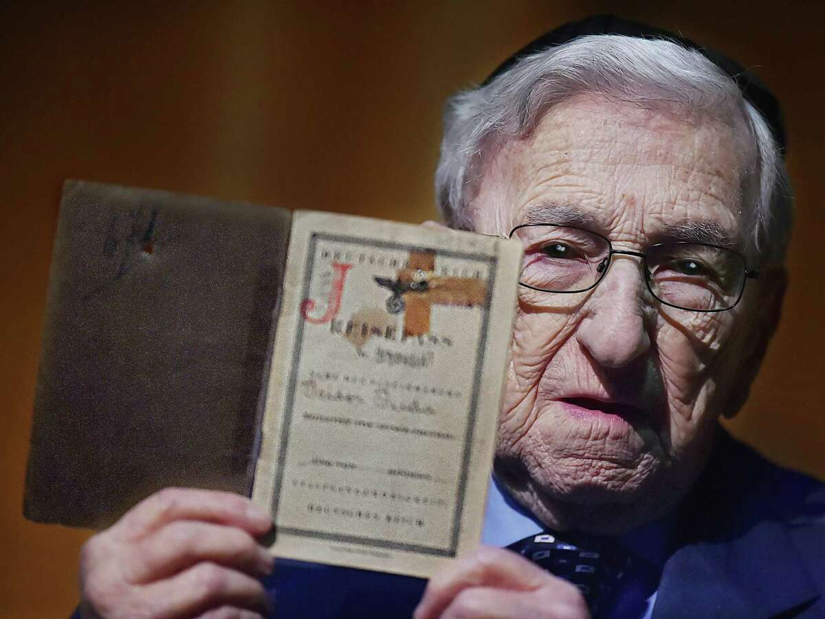 New Haven resident and Holocaust survivor Isidor Juda, 96, holds his passport at the Holocaust Remembrance Day at Bucknall Theater at the University of New Haven Tuesday in West Haven.