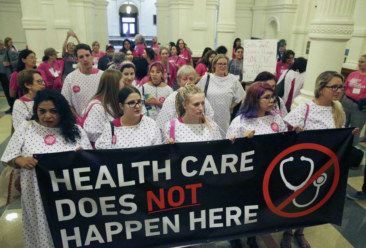 Demonstrators for women's health care issues approach the Texas governor's office during the the special session on July 26, 2017.