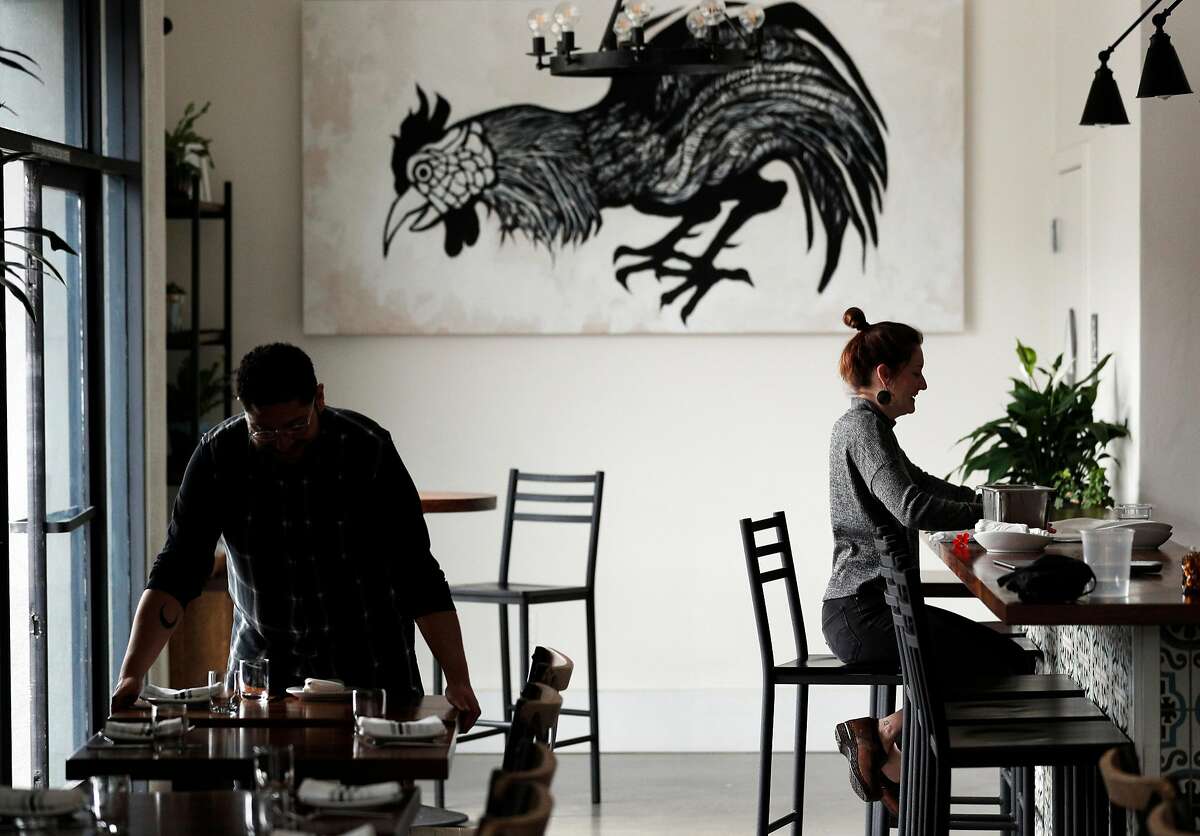 Julia Middlemiss, left, and Bryan Espinal, get the dining room ready during dinner prep time at Son's Addition restaurant in San Francisco, Calif., on Tuesday, April 10, 2018. The restaurant industry is feeling new tensions surrounding ICE raids and inspections, as workers who might be undocumented are nervous of being caught in immigration sweeps.