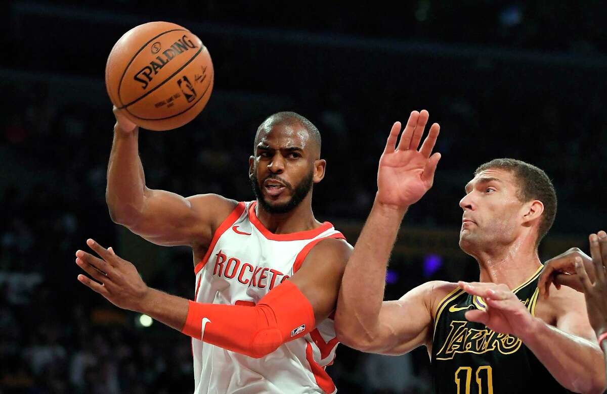 Houston Rockets guard Chris Paul, left, passes the ball as Los Angeles Lakers center Brook Lopez defends during the first half of an NBA basketball game Tuesday, April 10, 2018, in Los Angeles. (AP Photo/Mark J. Terrill)